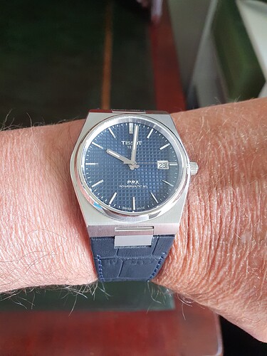 Tissot PRX met leren band om de pols 28e